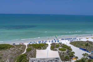 A beach with umbrellas and a clear view of the ocean. - Siesta Sands Private Beach | Gulf Views | Htd Pool (Sarasota)
