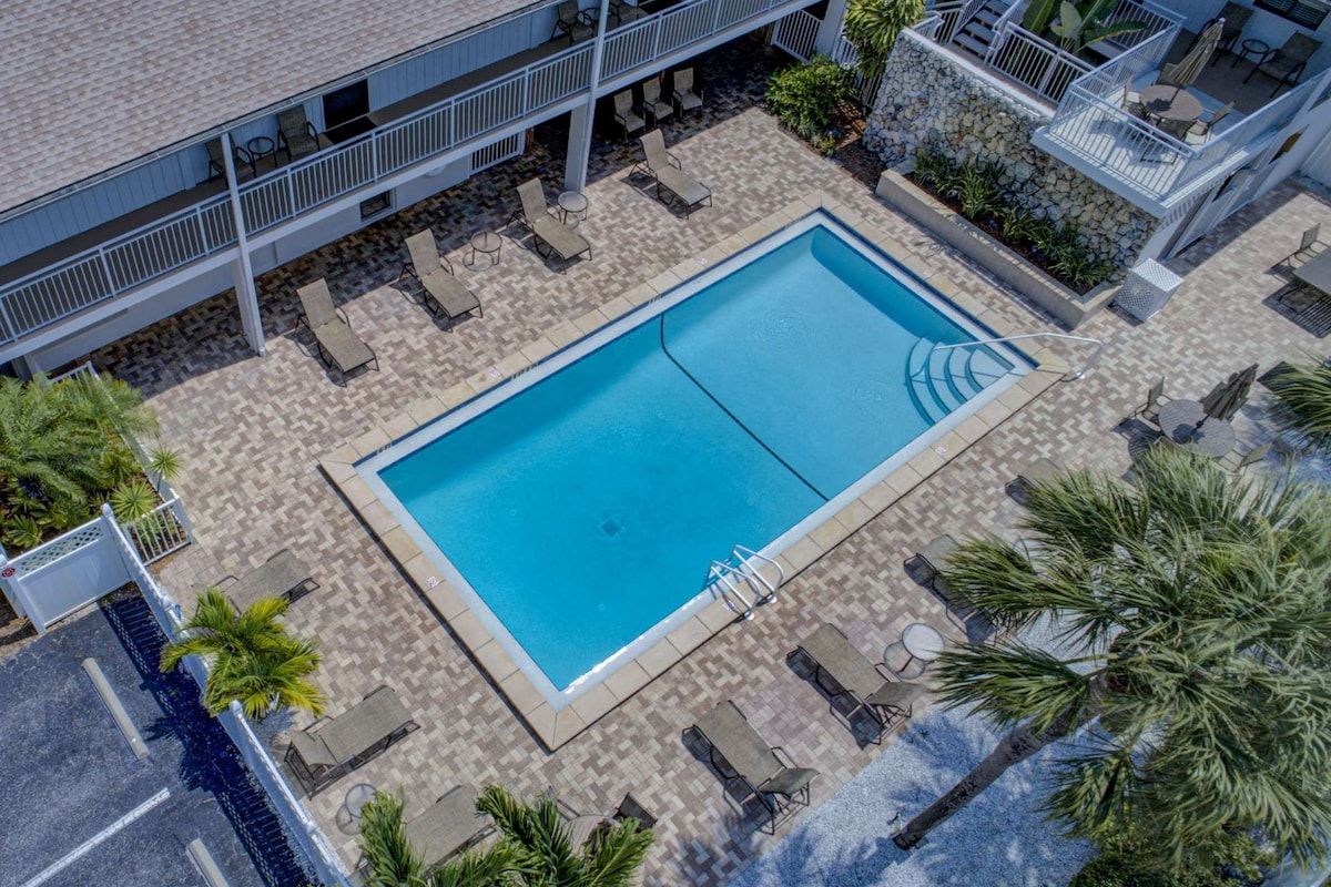 A rooftop pool area with lounge chairs and a swimming pool.
