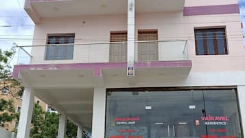 A multi-story building with a glass entrance displaying "Vairavell Residency" and "A/C Non-A/C rooms available."
