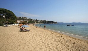 Playa en los alrededores, playa de arena blanca y camastros 
