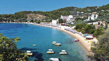 Una playa cerca, arena blanca, sillas reclinables de playa