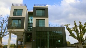 Un bâtiment moderne à deux étages, doté de grandes fenêtres et d’un toit plat.