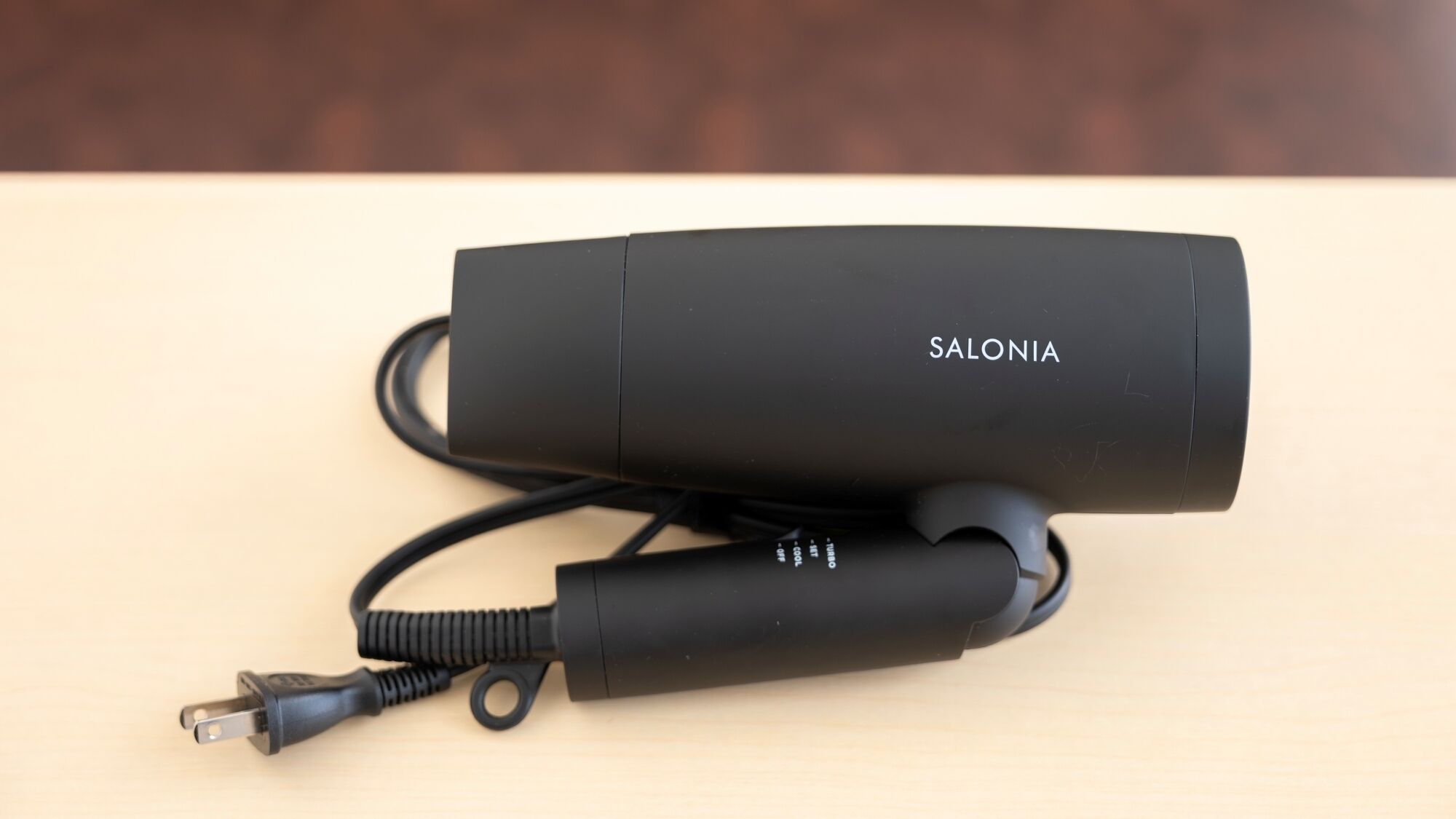 Un cargador portátil negro con un cable y un conector USB, etiquetado como "SALONIA".