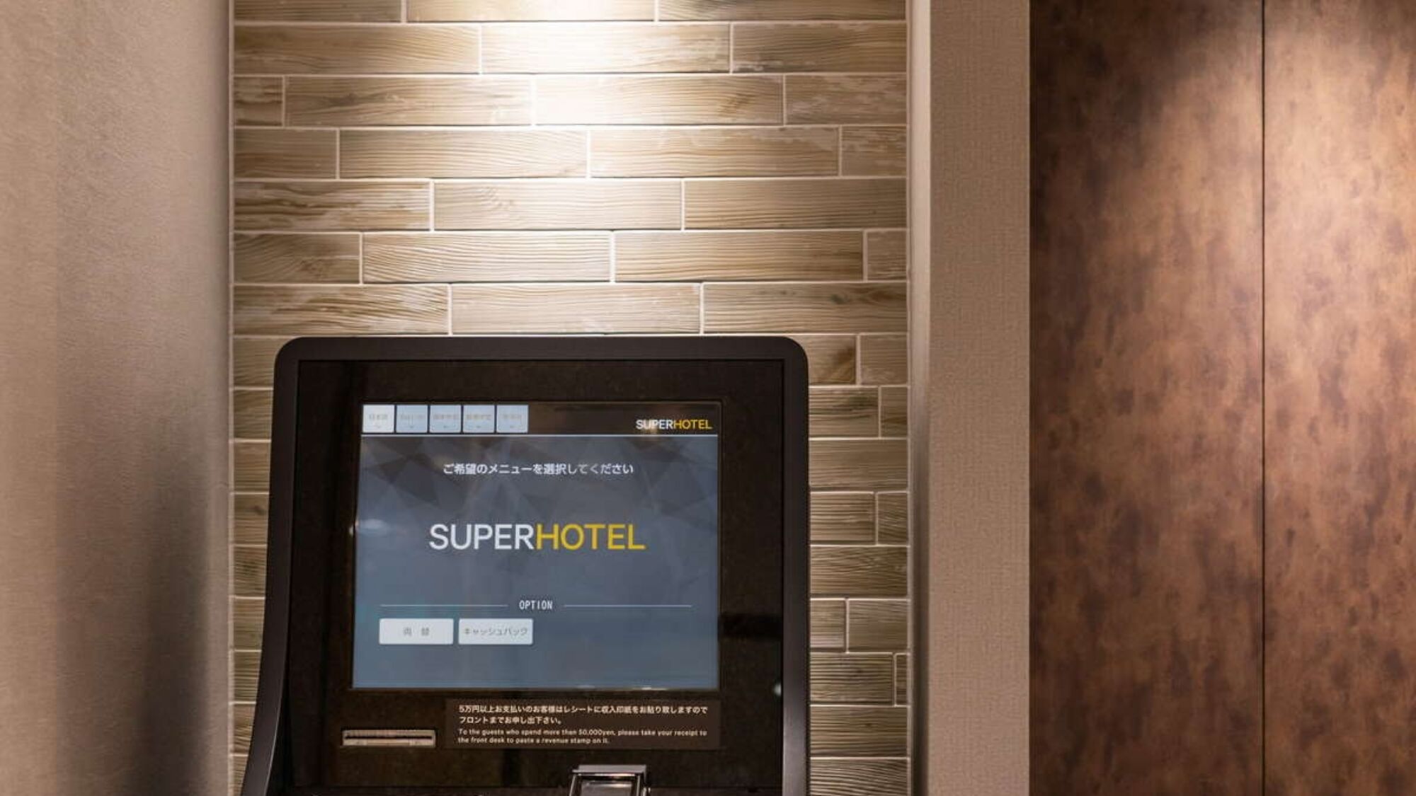 A digital kiosk with a SuperHotel interface, indicating a self-service option for guests.