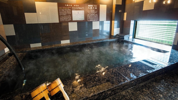 A hot spring area with tiled walls and informational plaques. - Super Hotel Totsuka Station East (Yokohama)