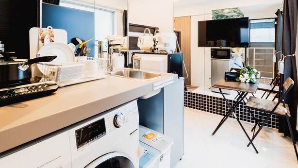 A compact kitchen with a washing machine, a microwave, and a sink.