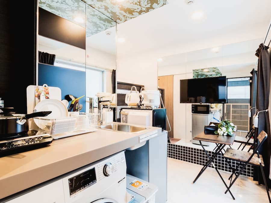 A compact kitchen with a washing machine, a microwave, and a sink.