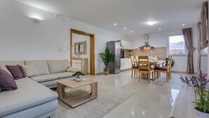 Una sala de estar moderna con un sofá, una mesa de centro y un comedor con sillas y una mesa.