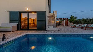 A swimming pool with a glass enclosure, outdoor seating, and a staircase leading to an upper level. - Villa Ivo (Posedarje)