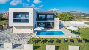 A modern two-story house with a swimming pool, outdoor seating, and a view of the surrounding landscape. - Villa F&A (Sveti Filip i Jakov)