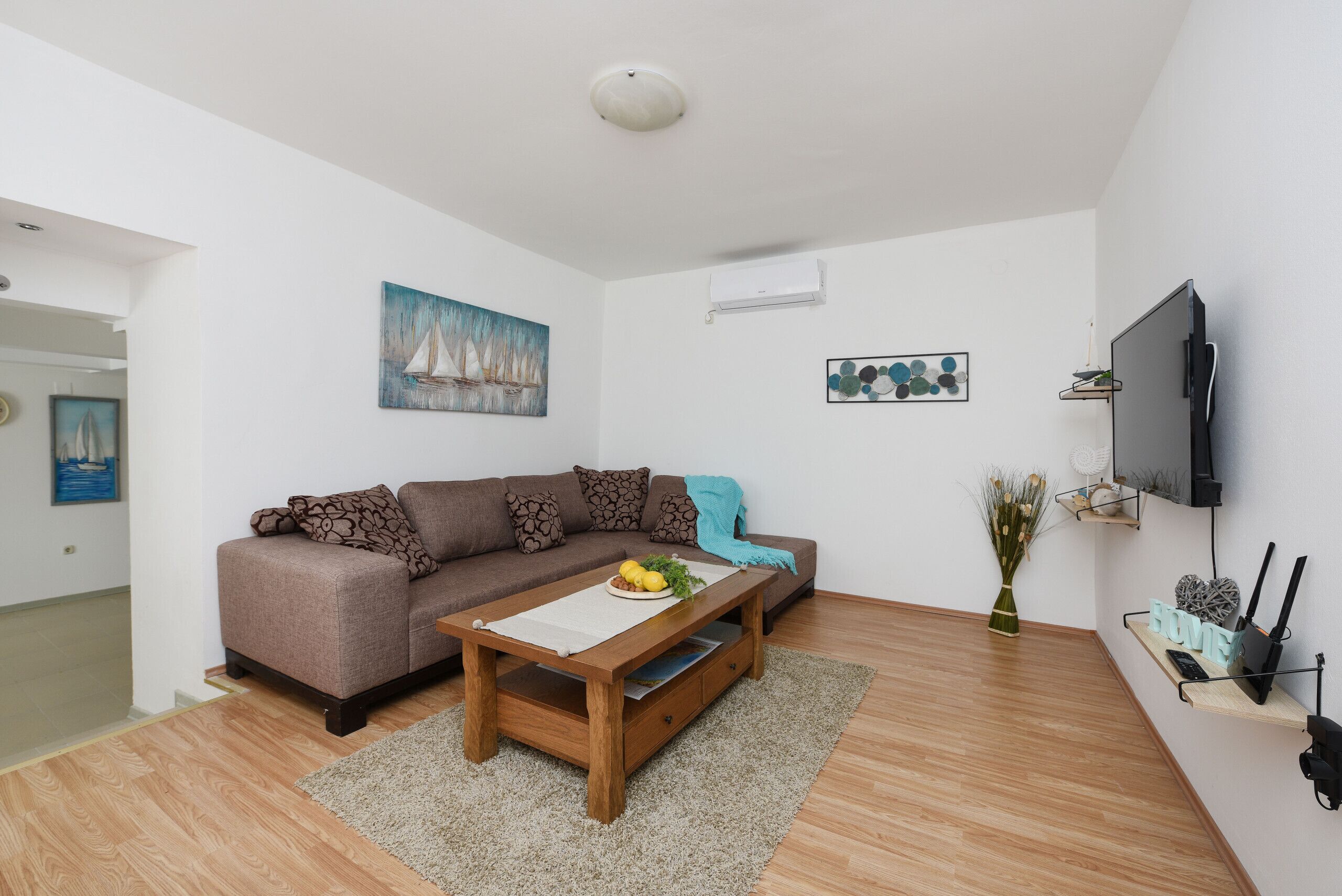 A modern living room with a sofa, coffee table, and artwork on the walls.