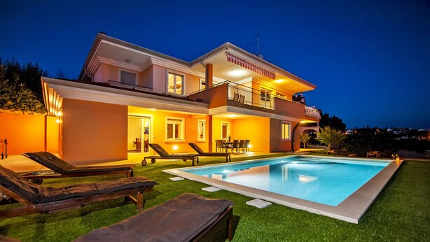 A modern two-story house with a swimming pool, outdoor seating, and a well-lit balcony. - Villa Sky (Rovinj)