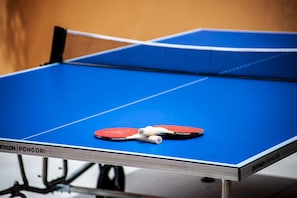Una mesa de tenis de mesa con dos paletas rojas y una red.