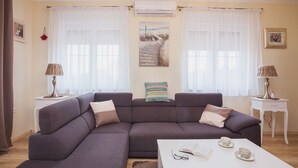 Una sala de estar con un sofá modular, una mesa de centro y dos mesitas de noche con lámparas.
