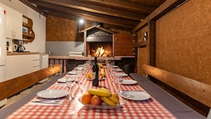 A long dining table with a red and white checkered tablecloth, surrounded by chairs, with a bottle of wine and a fruit bowl in the center. - Villa Dandelion (Benkovac)