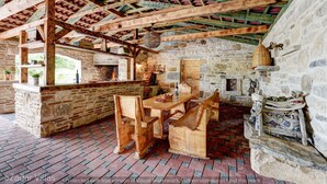 A rustic wooden interior with exposed beams, stone walls, and a brick floor. - Villa Smilje (Posedarje)