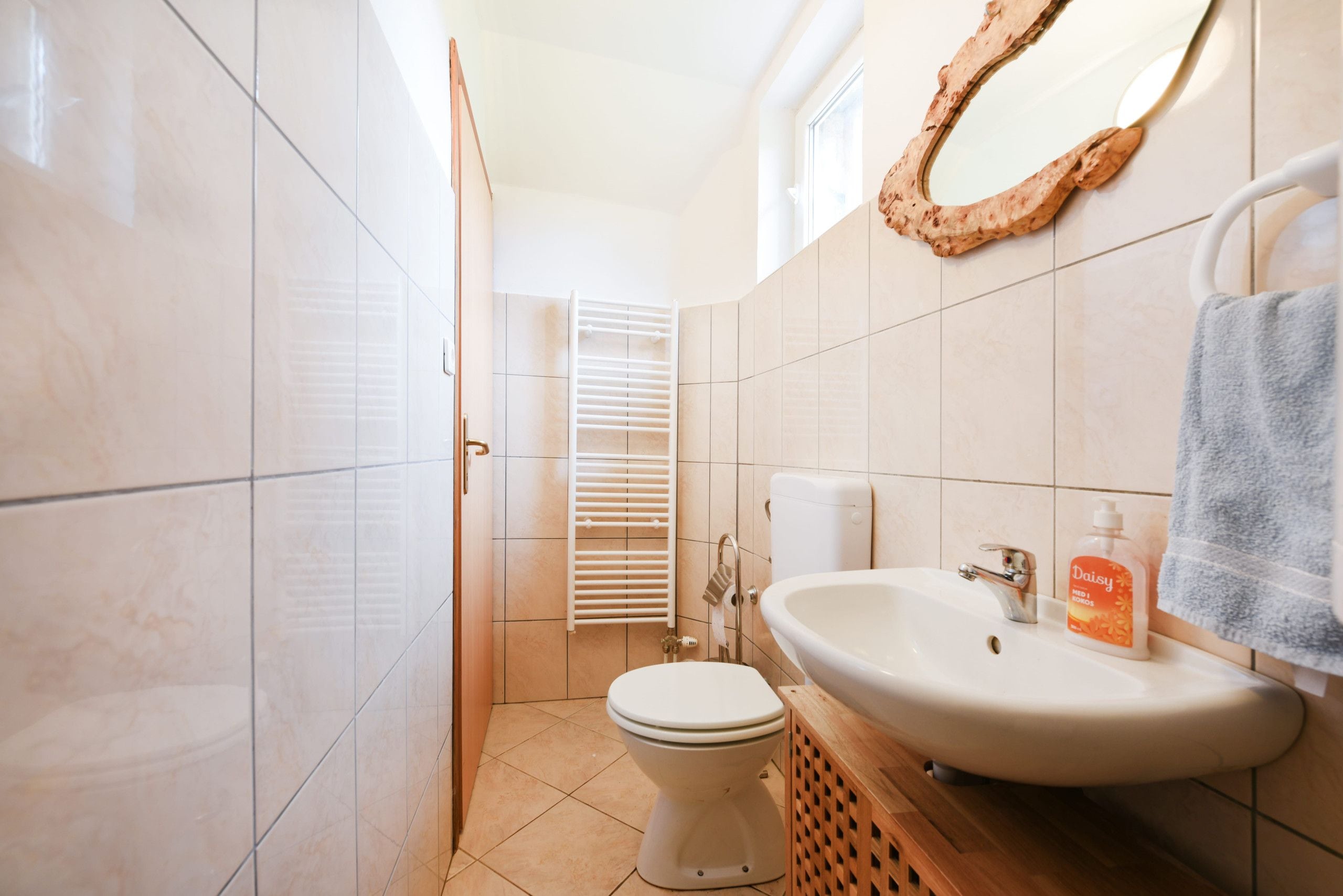 A bathroom with a toilet, sink, and towel rack.