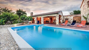 A pool with lounge chairs, a stone building with a tiled roof, and a sunset sky. - Villa Smilje (Posedarje)