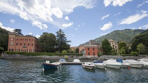 A waterfront with boats docked, historic buildings, and a clear sky. - Balbianino (Tremezzina)