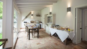 A dining area with a table set for breakfast, a ship model on the wall, and a cabinet with glass doors. - Balbianino (Tremezzina)