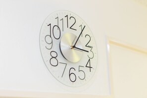 Une horloge murale avec un cadran blanc et des chiffres noirs.