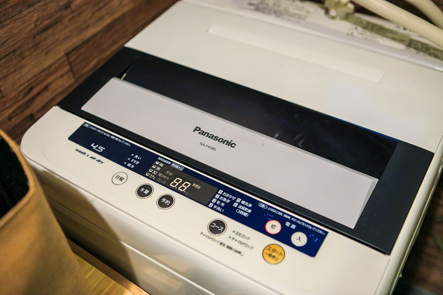 A Panasonic NA-F4585 washing machine with a digital display, control panel, and various buttons.