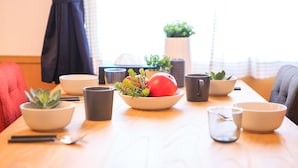 Een eettafel met kommen, bekers en een fruitschaal.