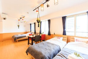 A hotel room with two single beds, a dining table, chairs, and hanging plants. - Dai 15 prosper Apartment (Nagoya)
