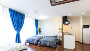 A modern hotel room with two beds, a kitchenette, and a small dining area. - Dai 40 prosper Apartment (Nagoya)