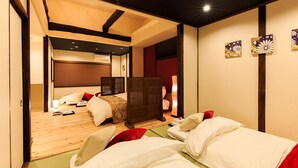 A traditional Japanese-style bedroom with tatami flooring, a low wooden bed, and shoji screens. - ORIGAMI STAY -Taishocho- (Nagoya)