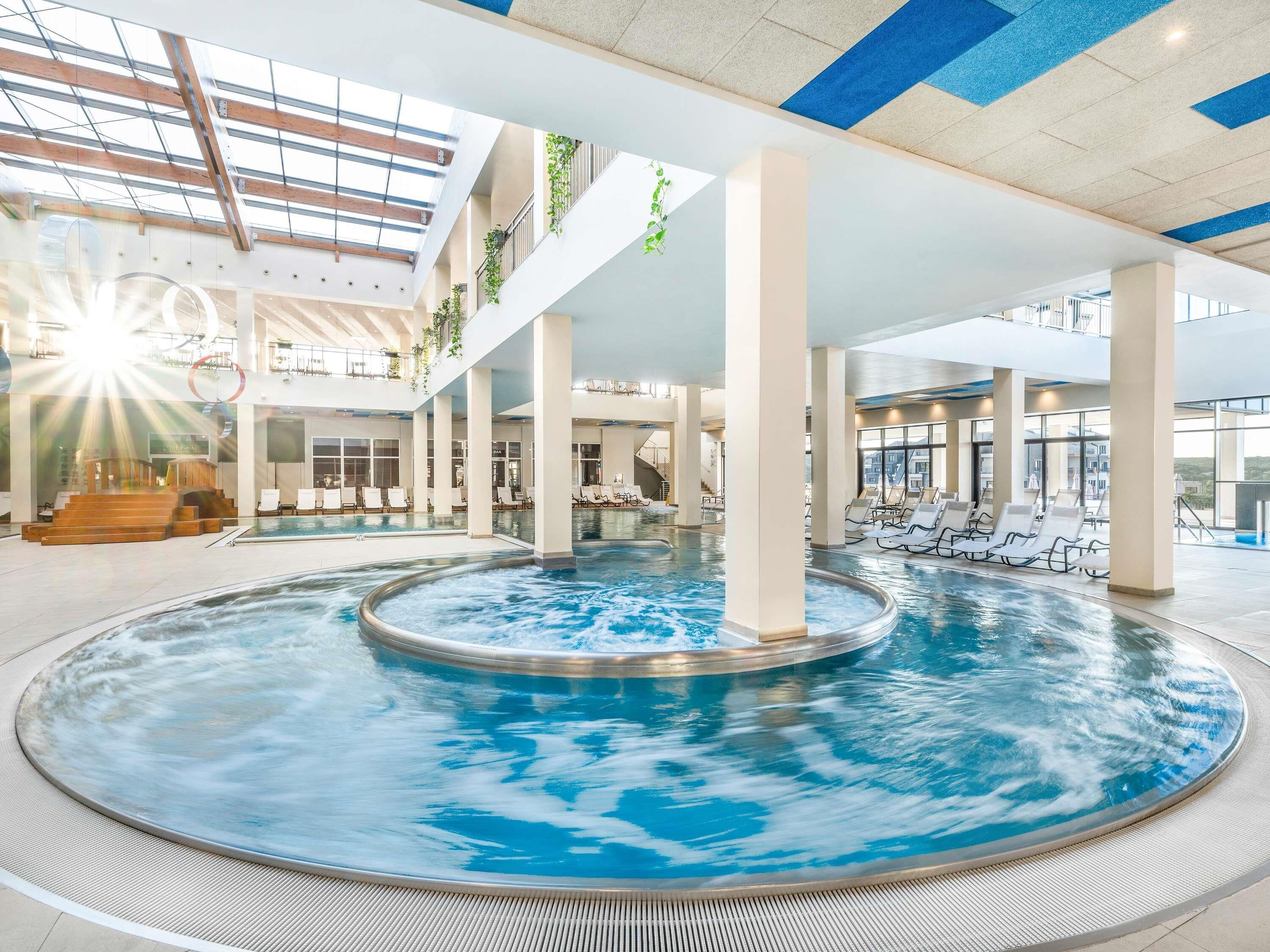 Una piscina cubierta, una piscina al aire libre de temporada, tumbonas