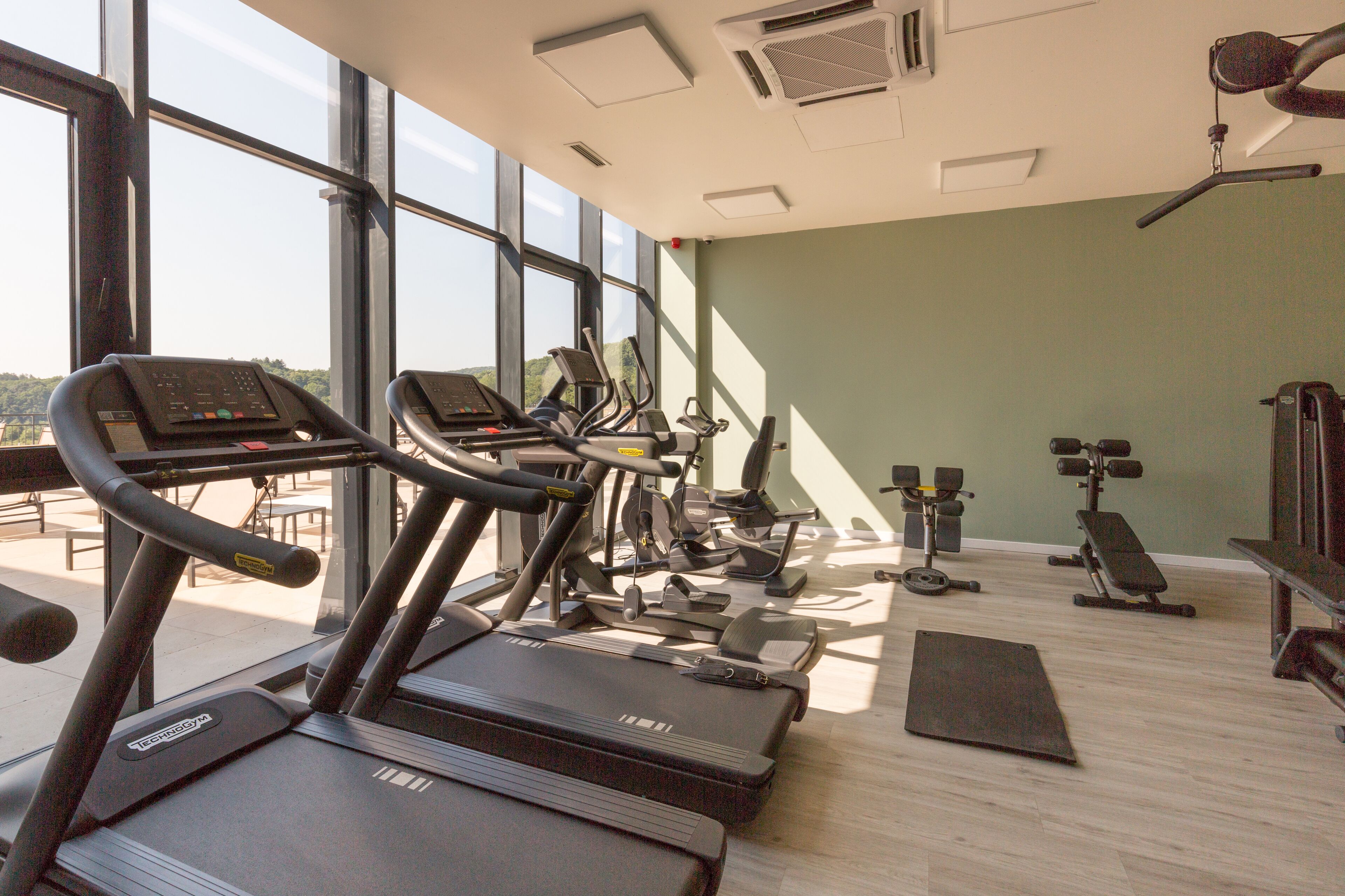 A gym with treadmills, elliptical machines, and weight equipment.