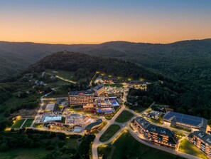 A resort with multiple buildings, a swimming pool, and a parking area. - Mövenpick Resort and Spa Fruske Terme  (Vrdnik)