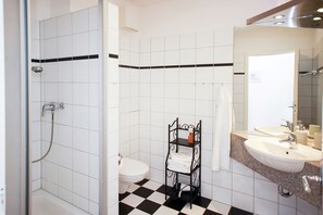 Ein Badezimmer mit Dusche, Toilette und Waschbecken.