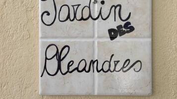 A white tile with black text that reads "Tardin des Bleandes."