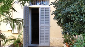 Un sentiero di cemento stretto che conduce a un edificio con una porta e una finestra.
