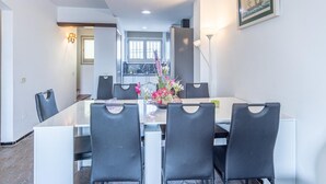 A modern dining area with a rectangular table, six black chairs, and a vase of flowers. - Fisherman's house, 4 bedrooms, mooring, WIFI, beach very close. (Empuriabrava)