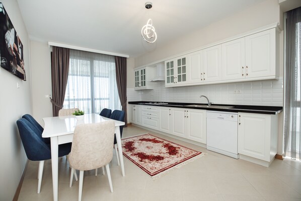 Suite Deluxe | Cocina privada | Refrigerador, microondas, horno y parrilla de estufa