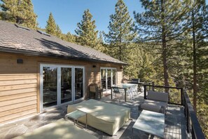A wooden cabin with a patio area featuring outdoor furniture and a dining table. - Skylake Serenity Retreat (Incline Village)