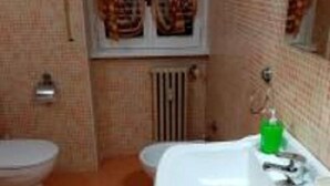 A small bathroom with a toilet, a sink, and a mirror. - Olimpica Relais Guest House Affittacamere CIR 28624 (Rome)