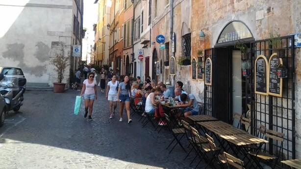 A narrow street with outdoor seating at a restaurant. - Olimpica Relais Guest House Affittacamere CIR 28624 (Rome)
