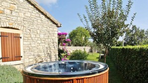 A wooden hot tub in a garden with a stone building in the background. - Holiday Homes Ana & Maria (Kanfanar)