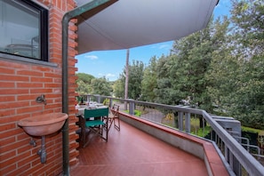 A balcony with a brick wall, a terracotta sink, and a table with chairs. - Francesca 2 600m From Sea (Massa)