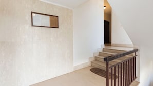 Un escalier avec une rampe en bois et des murs de couleur beige.