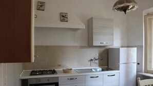 A kitchen with a stove, oven, sink, and a refrigerator. - Il Gladiolo - Focette 100mt From Sea (Pietrasanta)