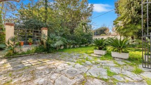 A courtyard with stone paving, potted plants, and a metal gate. - Il Gladiolo - Focette 100mt From Sea (Pietrasanta)