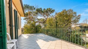 A balcony with a tiled floor, a metal railing, and a white plastic chair. - Il Gladiolo - Focette 100mt From Sea (Pietrasanta)