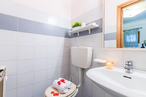 Ein Badezimmer mit Toilette, Waschbecken und Spiegel.