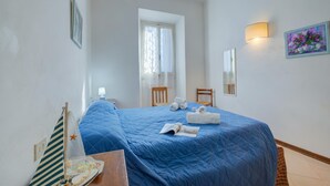 A bedroom with a bed, a chair, a desk, a window, and a wall-mounted lamp. - La Fresia - Focette 100mt From Sea (Pietrasanta)