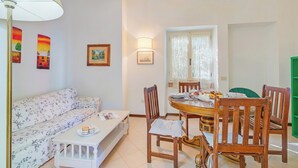 A dining area with a table, chairs, a sofa, and a lamp. - La Fresia - Focette 100mt From Sea (Pietrasanta)
